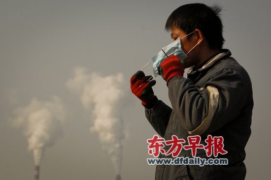 2013年12月13日，一名外来务工者因无法忍受南京八卦洲岛上的刺鼻气味而戴上口罩工作。早报记者