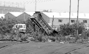 一辆车运着满满一车垃圾过来倾倒