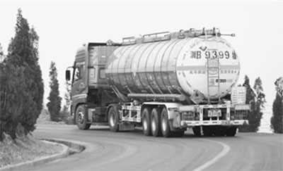 危化品车在山路一转弯处，右边是陡坡。