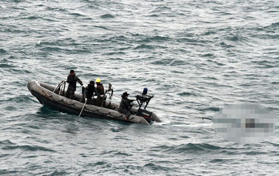 资料图：印尼海军士兵利用快艇运送遇难者遗体。