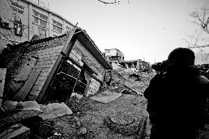 一间倒塌在坑内的房屋已经被回填的沙土埋了一半。 张静雅 摄